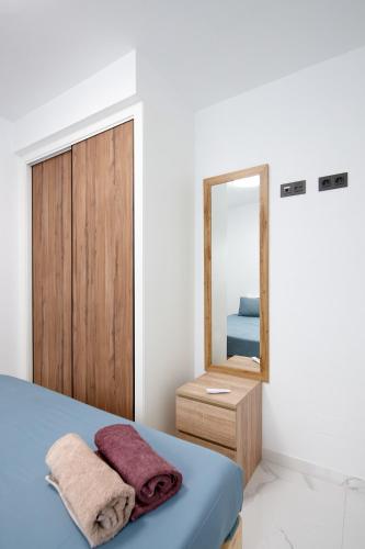 a bedroom with a blue bed and a mirror at Eco-Torrevieja in Torrevieja