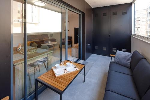 a living room with a blue couch and a table at Eco-Torrevieja in Torrevieja