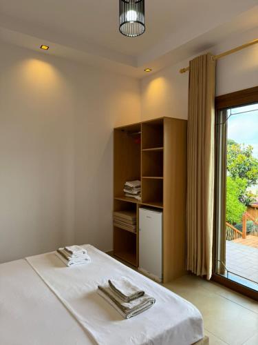 a bedroom with a bed and a large window at Villa Verde Vlore in Vlorë