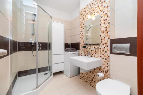ein Bad mit einem WC, einem Waschbecken und einer Dusche in der Unterkunft Apartament Sopot Haffnera in Sopot