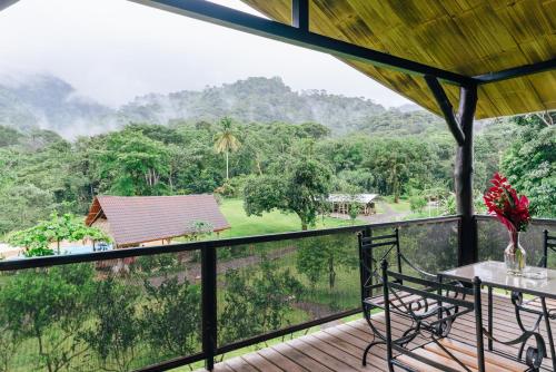 a balcony with a view of a forest at Hacienda Mil Bellezas - Private 40ha Jungle Reserve in Quepos