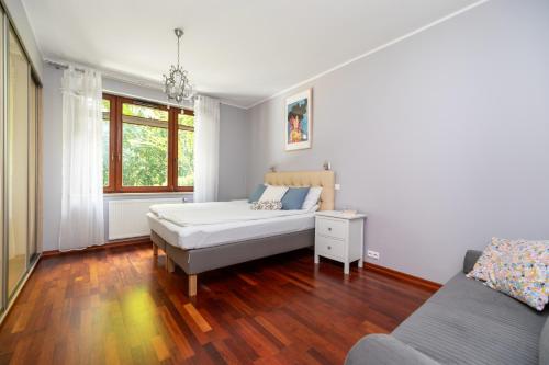 ein Schlafzimmer mit einem Bett und einem Sofa in der Unterkunft Apartament Sopot Haffnera in Sopot