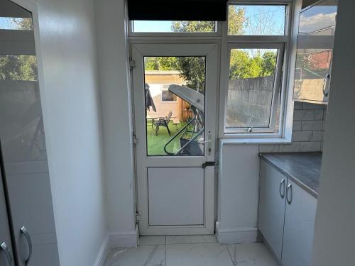 a kitchen with a door with a view of a yard at ELSARO guest house in Slough