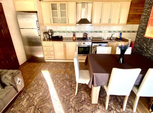 a kitchen with a table and chairs and a refrigerator at VİLLA ANATOLİA in Alanya