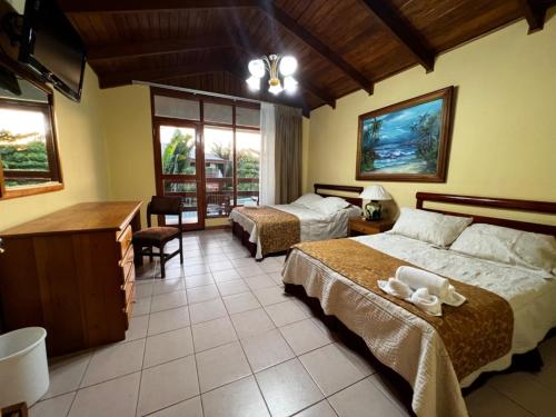 a hotel room with two beds and a desk at Amapola Resort in Jacó