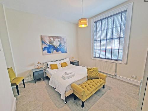 a bedroom with a bed and a chair and a window at Canal Side 2 Bedroom Apartment in Leamington Spa