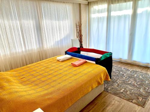 a bedroom with a large bed with a yellow bedspread at VİLLA ANATOLİA in Alanya