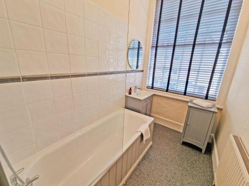 a bathroom with a bath tub and a sink at Canal Side 2 Bedroom Apartment in Leamington Spa