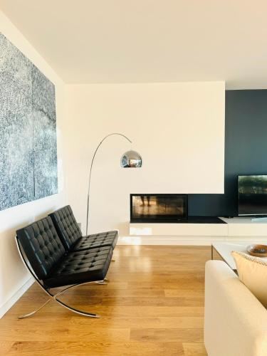 a living room with a black chair and a couch at Narciso Townhouse in Faro