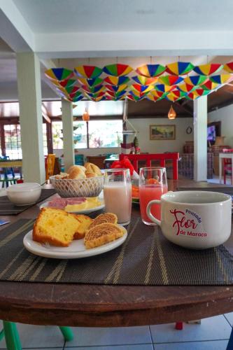een tafel met een bord eten en een kop melk bij Pousada Flor de Porto in Porto De Galinhas