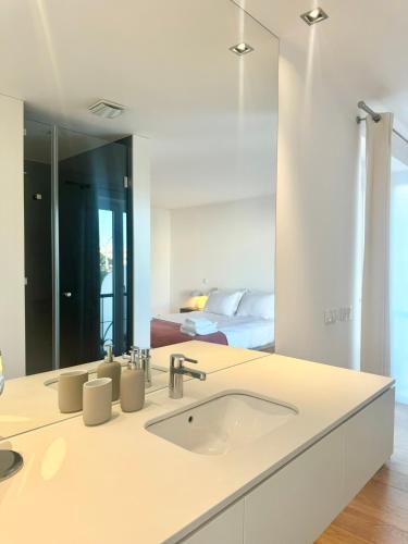 a bathroom with a sink and a large mirror at Narciso Townhouse in Faro