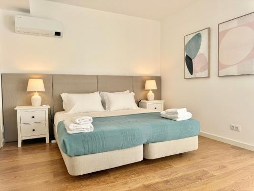 a bedroom with a bed with two night stands and two lamps at Narciso Townhouse in Faro
