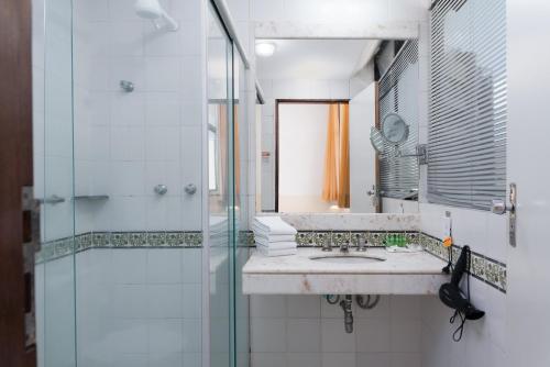 y baño con lavabo y ducha. en Ritz Plazamar Hotel, en Maceió