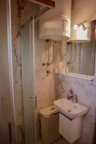 a small bathroom with a sink and a mirror at Guest House Godimento in Čilipi