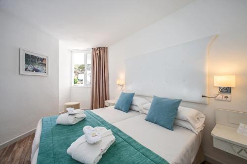 um quarto de hotel com uma cama com toalhas em FERGUS Style Cala Blanca Suites em Santa Ponsa