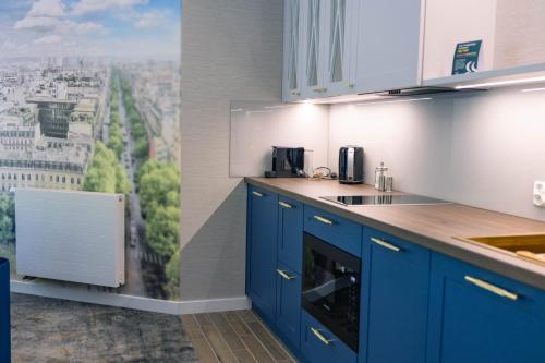 a kitchen with blue cabinets and a view of a city at Boulevard Boutique Suites in Łeba