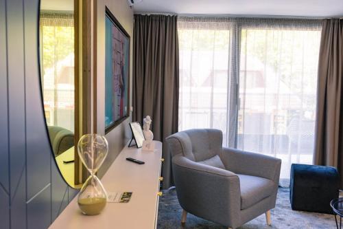 a room with a chair and a desk and a mirror at Boulevard Boutique Suites in Łeba