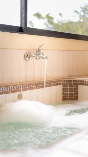 a bathroom with a tub with a water fountain at Hotel Alto de Pajas Boutique by H&R in Villeta