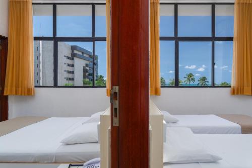 uma fila de camas num quarto com janelas em Ritz Plazamar Hotel em Maceió