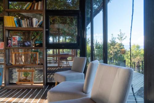 a living room with two chairs and a window at ECOREFUGIO in Colbún