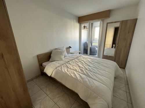 une chambre avec un grand lit dans une pièce dans l'établissement Appartement T3 rénové avec loggias, à deux pas de la mer et des commerces, parking privé inclus! - FR-1-324A-64, à Saint-Hilaire-de-Riez