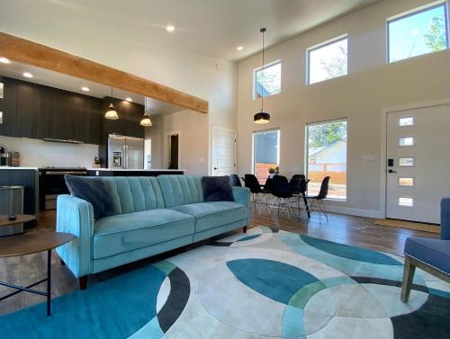 un soggiorno con un divano blu e una cucina di Timber & Tin C 2Bed 2Bath w Pool & Rooftop Deck a Kanab