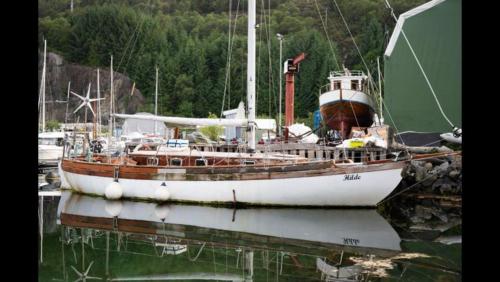 un barco está atracado en el agua en un puerto en Yacht - no shower en Arefjord
