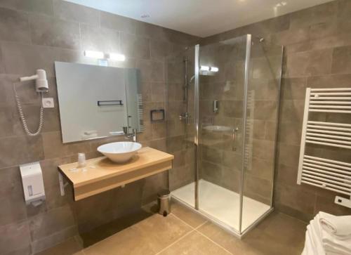 La salle de bains est pourvue d'une douche, d'un lavabo et d'une cabine de douche. dans l'établissement Entre montagne et mer, à Porto Ota