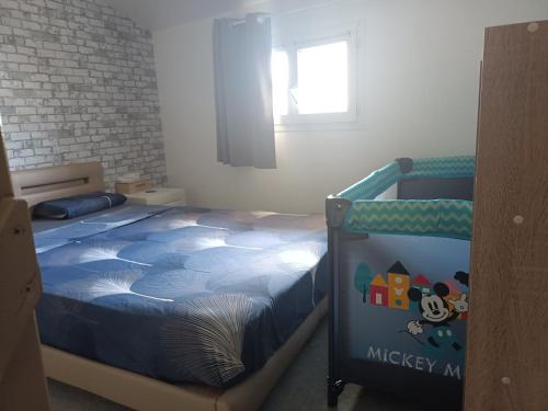 a bedroom with a bed with a blue comforter at Kedge 5 - proche centre, tram & universités in Talence