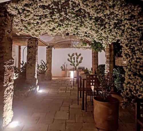 Pokój ze stołem, krzesłami i kwiatami w obiekcie Corte Piri w mieście Tricase