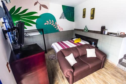 a living room with a couch and a bed at Tiny house Comulco con aire acondicionado. in Jalcomulco