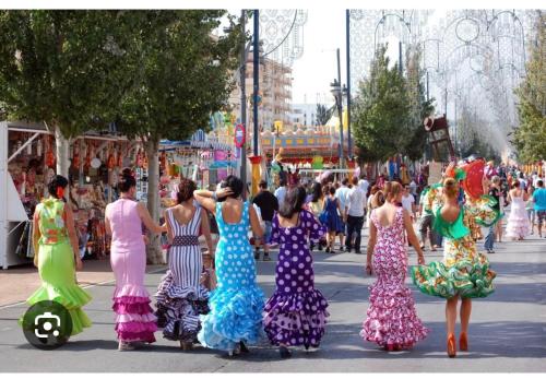 een groep vrouwen in jurken die over straat lopen bij Ramon - Y - Cajal in Fuengirola
