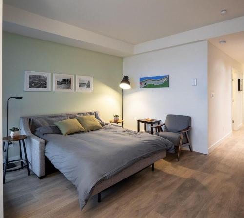 a bedroom with a large bed and a chair at Urban Stay With Balcony And In-Unit Laundry in Victoria