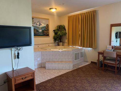 ein Wohnzimmer mit einer Badewanne und einem TV in der Unterkunft ABVI Westmorland in Westmorland