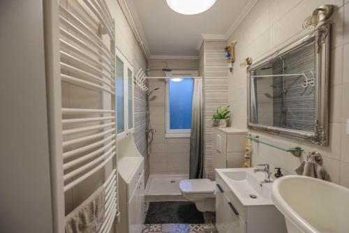a white bathroom with a sink and a toilet at Közel a strandhoz apartman in Eger