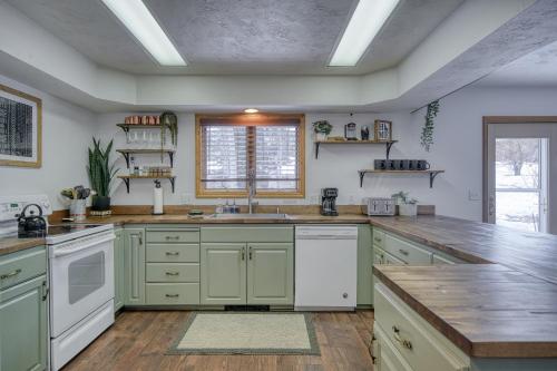 a large kitchen with green cabinets and a sink at Wapiti View 6-Bedroom Cabin 28mins to Yellowstone in Island Park