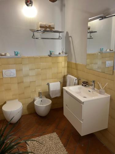 a bathroom with a sink and a toilet and a mirror at My Tuscany Relais in Altopascio