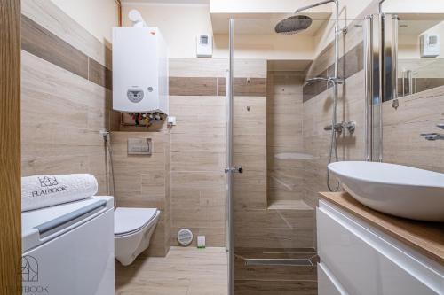 a bathroom with a toilet and a sink and a shower at Flatbook Apartamenty - Mikoszewo Wczasowa in Nickelswalde