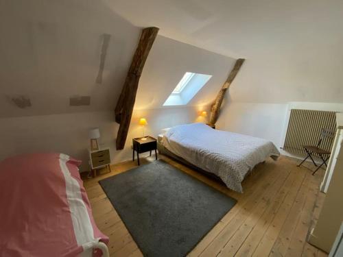 - une chambre avec un lit et une fenêtre mansardée dans l'établissement Maison LéoCha, à Sablons-sur-Huisne