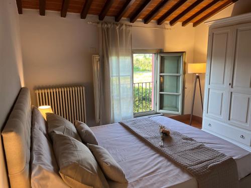 a large bed with a couch in a room with a window at My Tuscany Relais in Altopascio