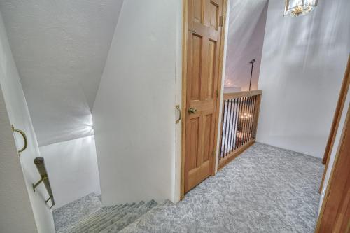 an empty hallway with a wooden door and a balcony at Wapiti View 6-Bedroom Cabin 28mins to Yellowstone in Island Park