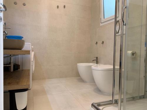 a bathroom with a glass shower and a toilet at Salentipity in Marina di Pescoluse