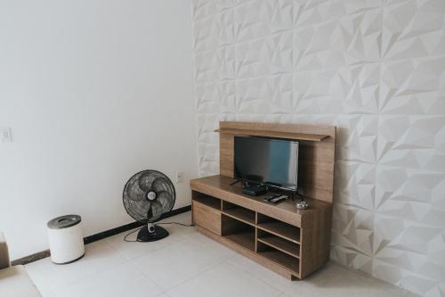 - un salon avec une télévision et un ventilateur dans l'établissement Recanto Kitnet, à Lagoa Santa