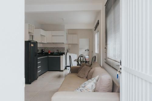 a living room with a couch and a kitchen at Recanto Kitnet in Lagoa Santa