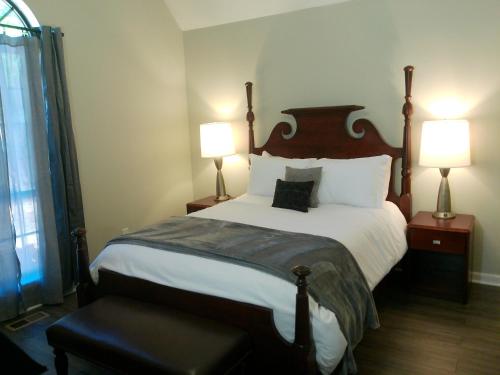 a bedroom with a large bed with two lamps at Trail Hollow in Sanford