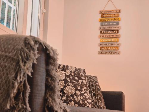 a couch in a room with a sign on the wall at La casita de Mercedes in Málaga
