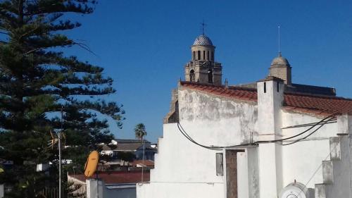 un edificio bianco con una torre dell'orologio sopra di PISO CENTRO HISTÓRICO 3 DORMITORIOS a Jerez de la Frontera