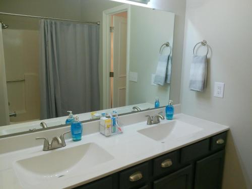La salle de bains est pourvue de 2 lavabos et d'un grand miroir. dans l'établissement Trail Hollow, à Sanford