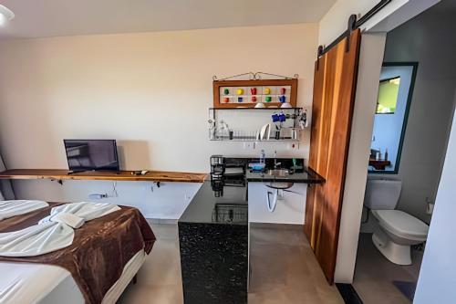 um quarto com uma cama e uma secretária com um computador portátil em Casa Varandas - Estúdio Budião (Tv+Frigobar+A/C) em Ubatuba