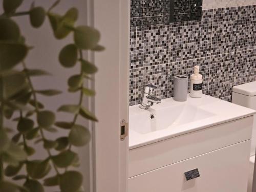 a bathroom with a white sink and aaucet at La casita de Mercedes in Málaga